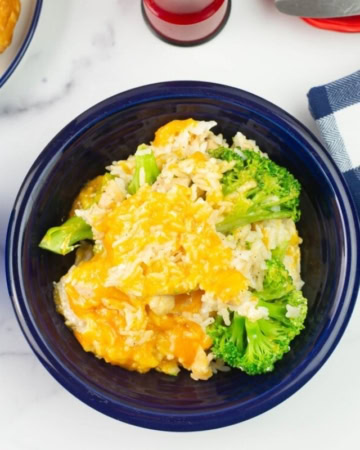 Overhead flat lay image of a serving bowl of the casserole with sliced bread and butter on the table.