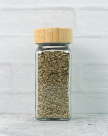 Homemade Italian Seasoning in a glass spice jar.