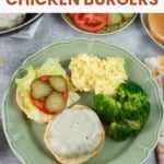 Homemade chicken burger topped with cheese on an open bun.