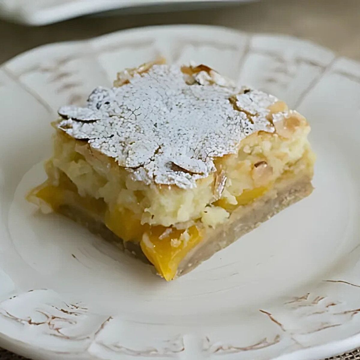 A slice of layered Peach Pie bars on a white plate.