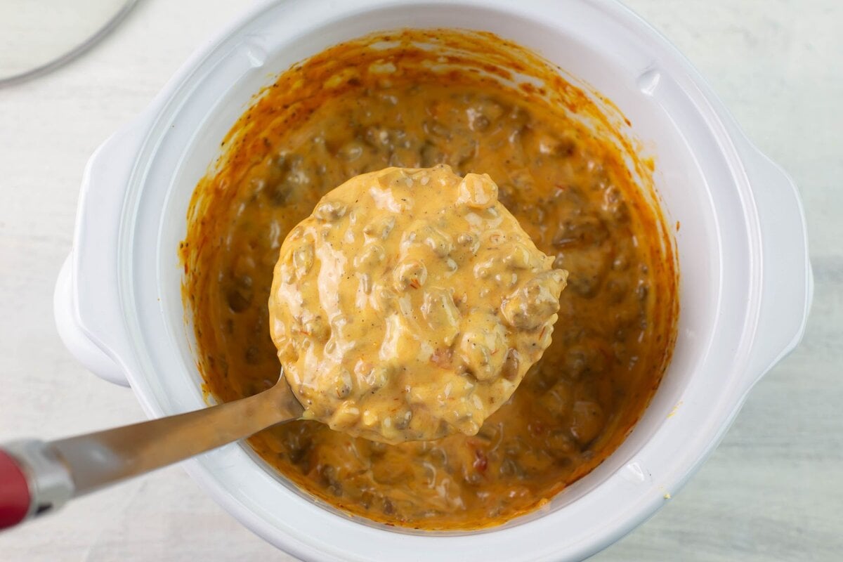 A ladle scooping up dip from the crock pot slow cooker.