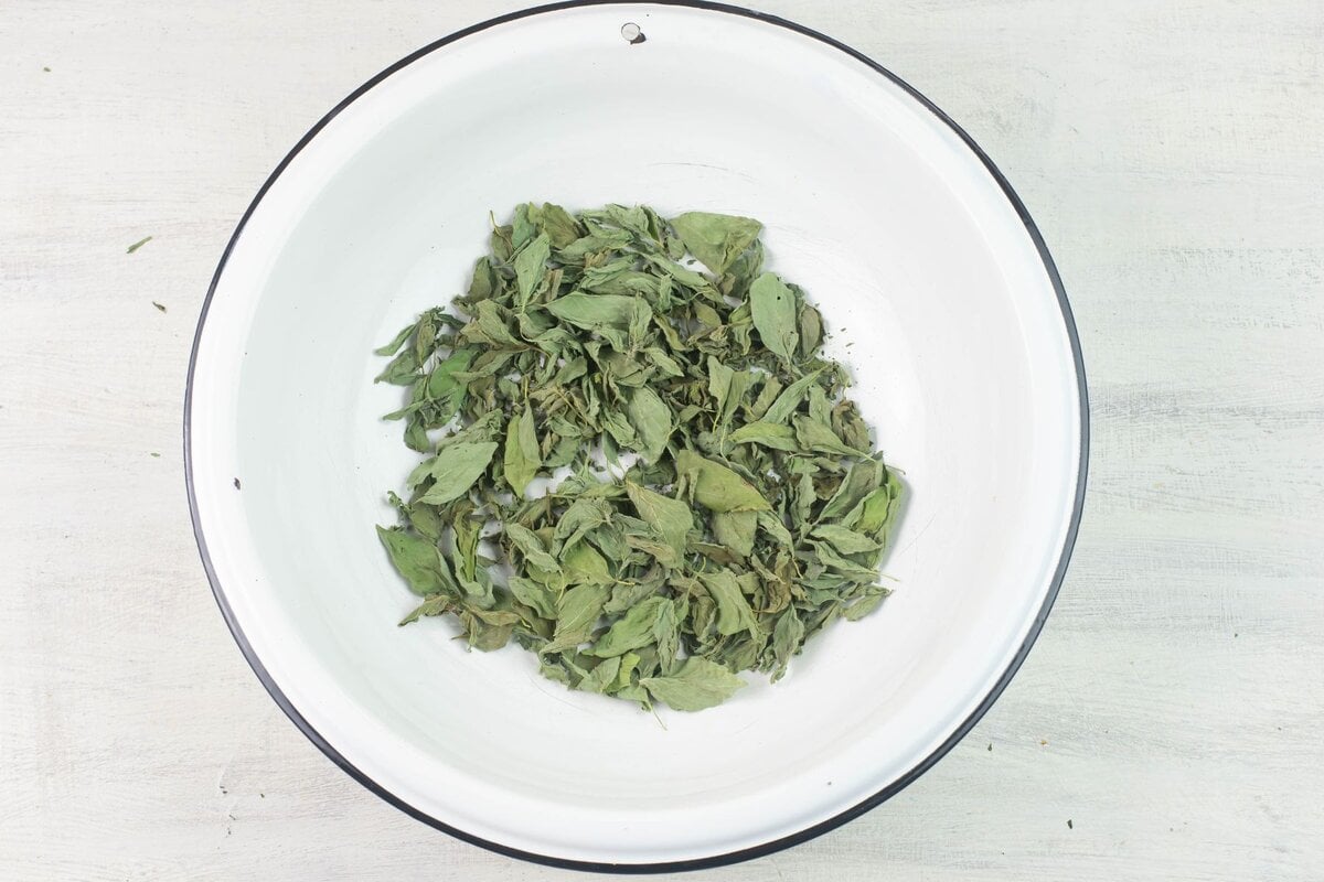 Whole and dried pieces of dried leaves in a large enamel bowl.