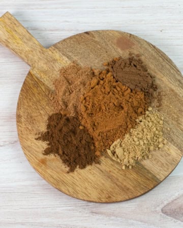Wooden board with pumpkin pie spices in mounds.
