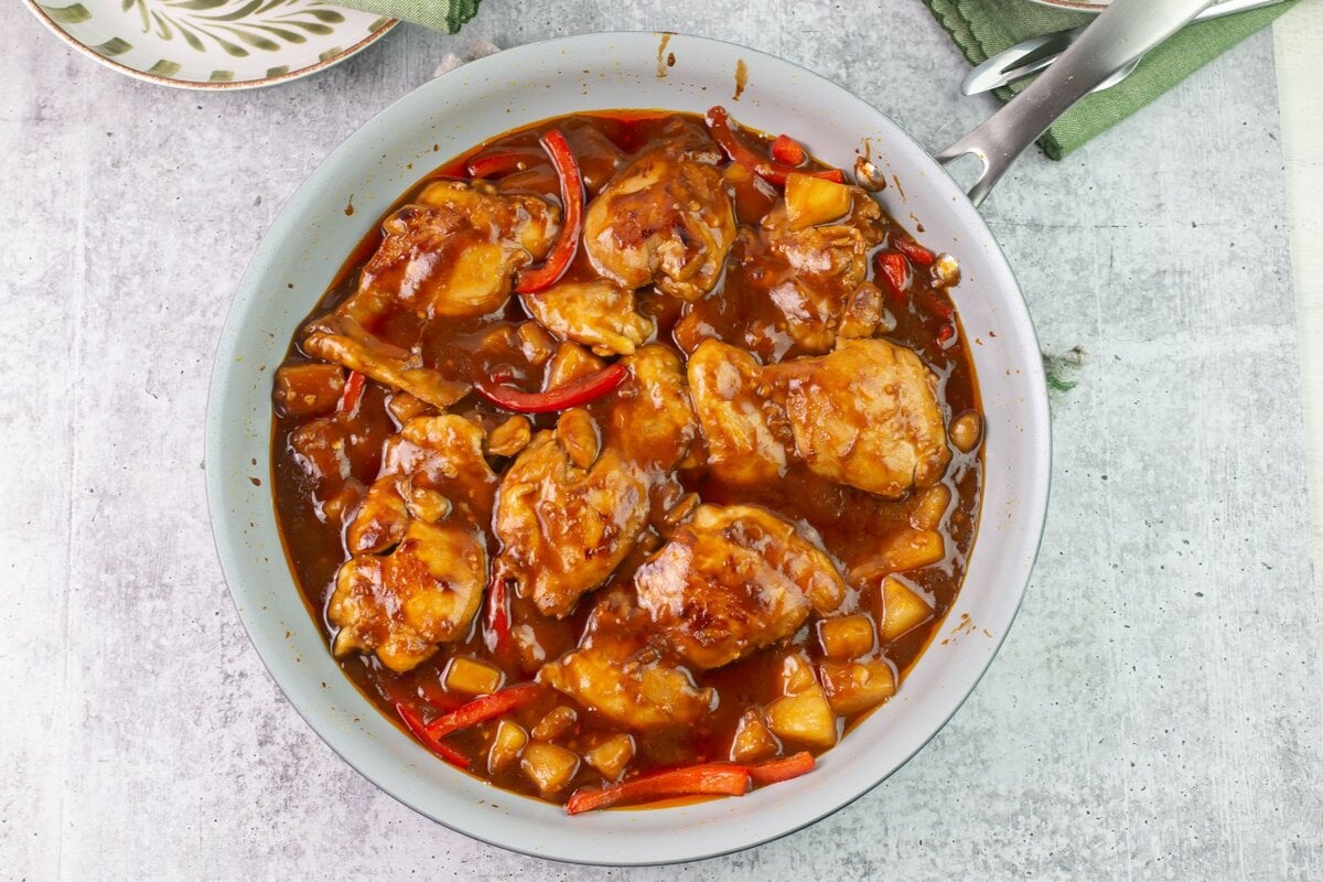 Cooked chicken thighs in a skillet.