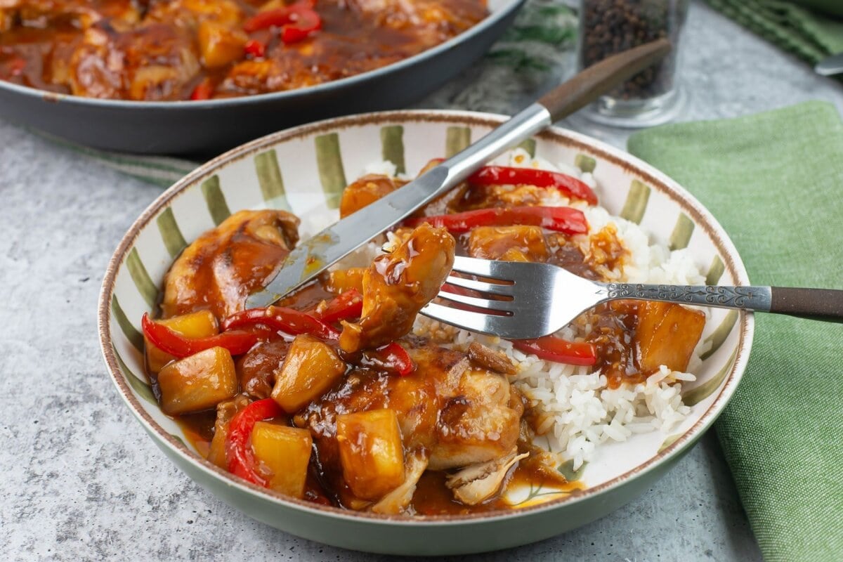 A bowl of sticky Hawaiian chicken thighs served over rice.