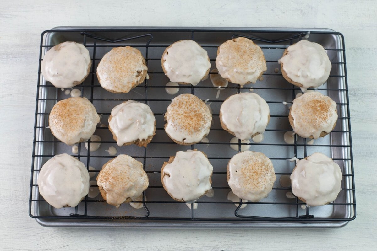 Icing dipped cookies on a wire rack so the excess icing can drip off.