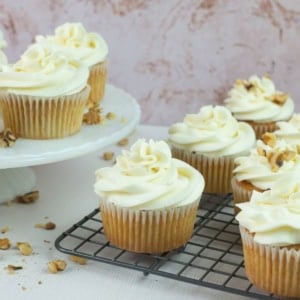 Frosted Carrot Cake Cupcakes on a wire rack and cake stand.
