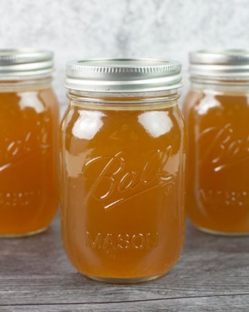Homemade turkey broth in three large mason jars.